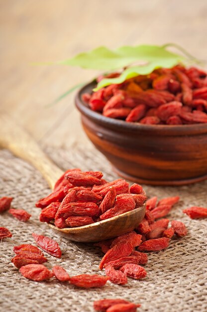 Bayas de goji secas rojas en cuchara de madera