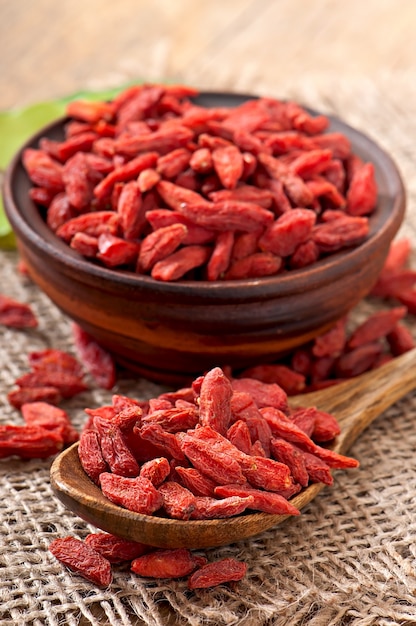 Bayas de goji secas rojas en cuchara de madera