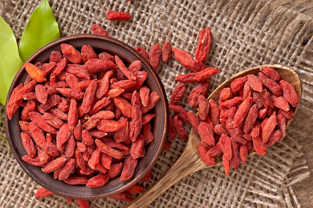 Bayas de goji secas rojas en cuchara de madera