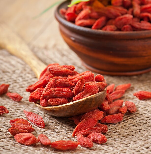 Bayas de goji secas rojas en cuchara de madera