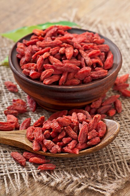 Bayas de goji secas rojas en cuchara de madera