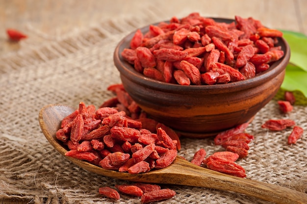 Bayas de goji secas rojas en cuchara de madera