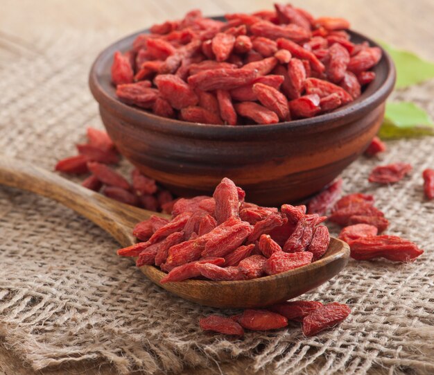 Bayas de goji secas rojas en cuchara de madera