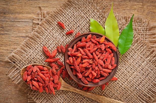 Bayas de goji secas rojas en cuchara de madera