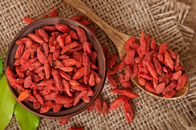 Bayas de goji secas rojas en cuchara de madera