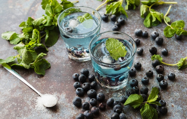 Bayas y menta alrededor de refrescantes bebidas de arándanos