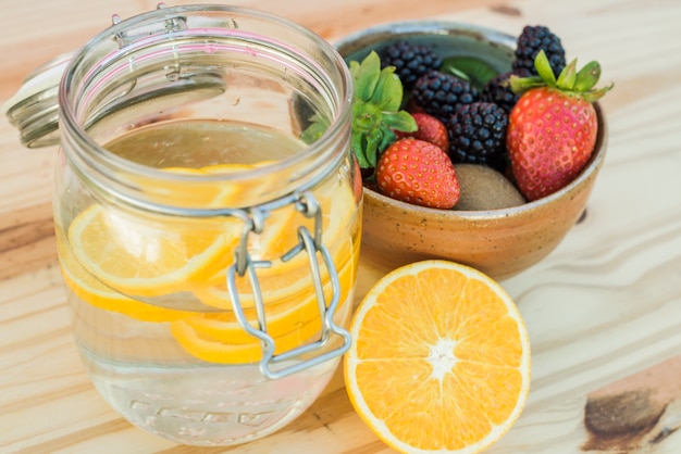 Foto gratuita bayas mezcladas y agua infundida de naranja