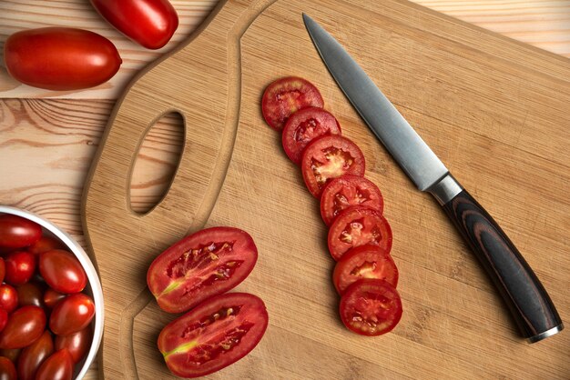 Bayas rojas y tomates en rodajas en la mesa de madera