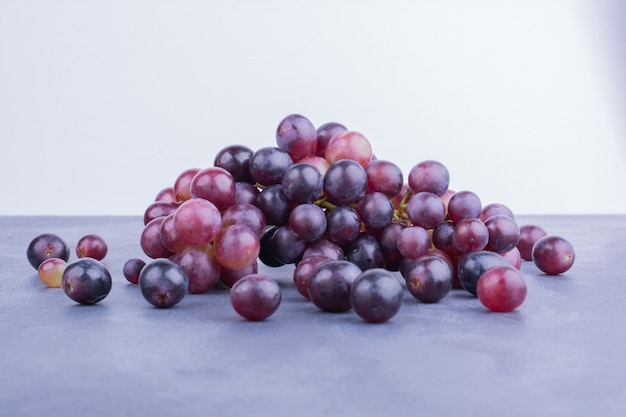 Bayas de uva roja sobre azul.