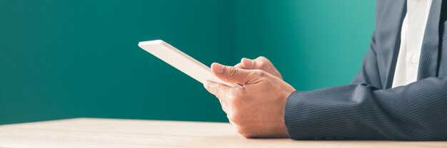 Bearded smiling asian man using tablet for video conversation while relaxing on sofa in office.Concept moderno de jóvenes empresarios que trabajan en casa. Bandera panorámica.