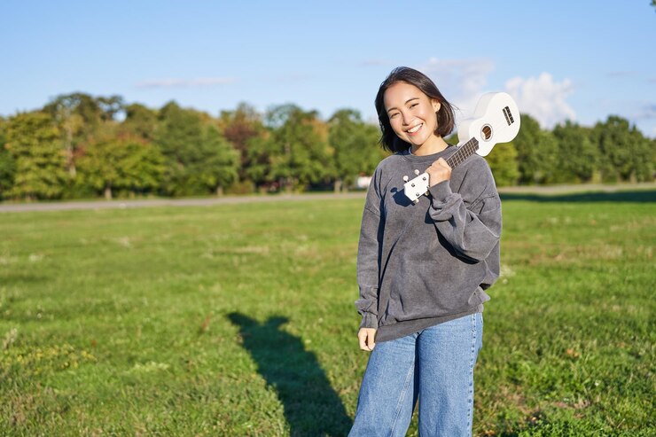 Photo Gratis beautiful korean girl posing with ukulele young musician playing outdoors in green park on sunny day