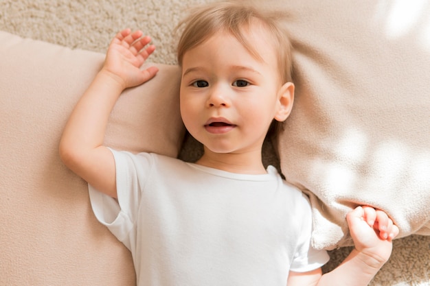 Bebé acostado plano sobre almohadas