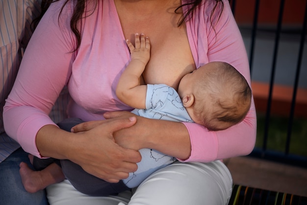 Foto gratuita bebé de alto ángulo madre amamantando