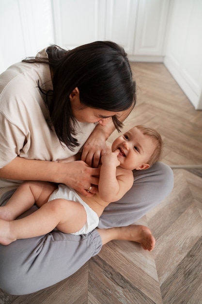 Foto gratuita bebé de alto ángulo madre cosquillas