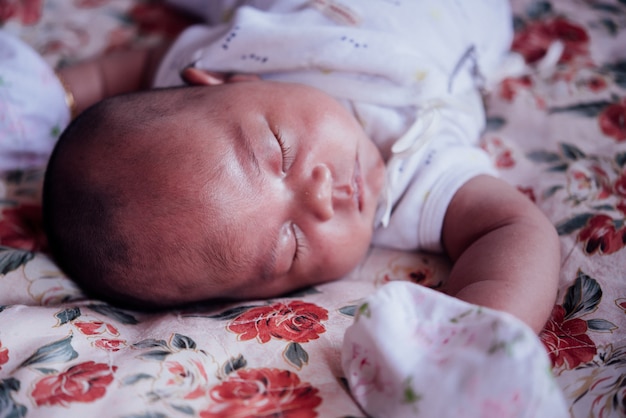 Bebé asiático durmiendo en la cama