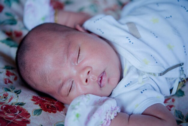 Bebé asiático durmiendo en la cama