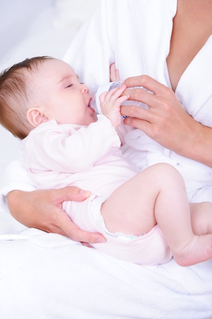 Bebé bebiendo leche del biberón por enfermera