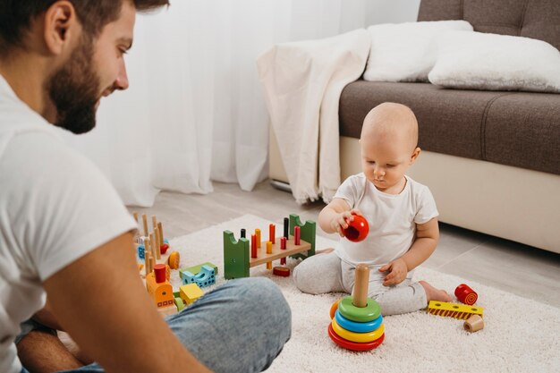 Bebé en casa jugando con su padre