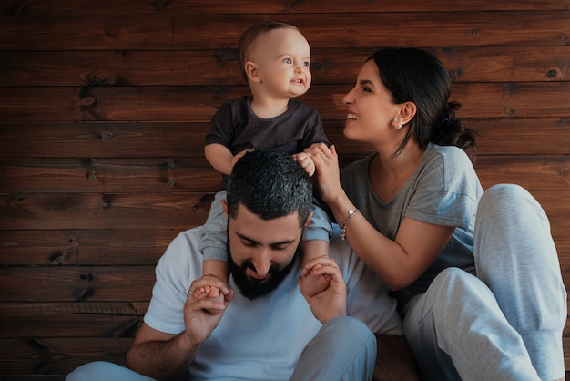 Foto gratuita bebé en los hombros de su padre y jugando con la madre.