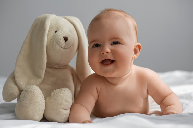 Foto gratuito un bebé lindo con un peluche