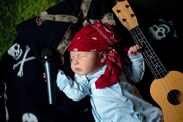Bebe En Un Panuelo Rockero Miente Con Una Guitarra Y Un Microfono Foto Premium Bebe En Un Panuelo Rockero Miente Con Una Guitarra Y Un Microfono Foto Premium