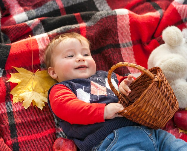 Bebé pelirrojo adorable que sostiene una cesta