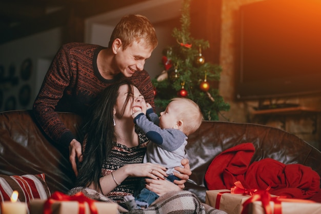 Foto gratuita bebé pellizcando y tocando la cara de su madre mientras el padre sonrie