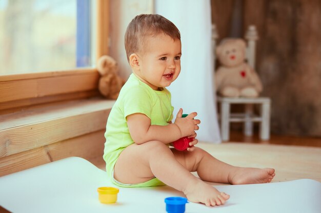 El bebé pequeño guarda una caja con pinturas