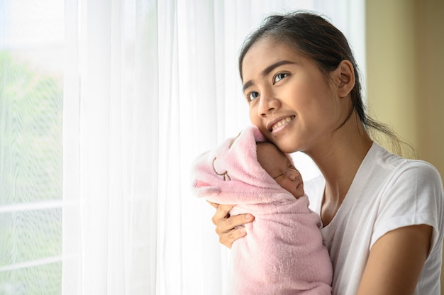 bebé recién nacido durmiendo en el abrazo de la madre