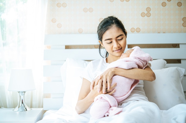 bebé recién nacido durmiendo en el abrazo de la madre