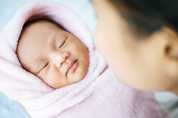 bebé recién nacido durmiendo en los brazos de la madre