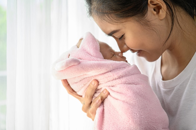 bebé recién nacido durmiendo en manos de la madre y la nariz chocó