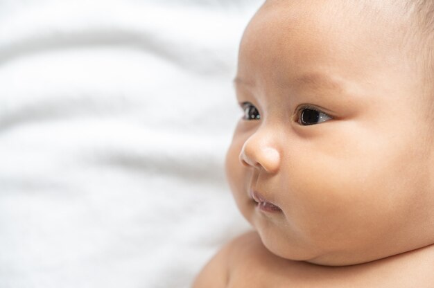 Un bebé recién nacido que abre los ojos y mira de reojo