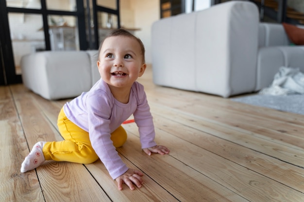 Bebé sonriente arrastrándose por el suelo