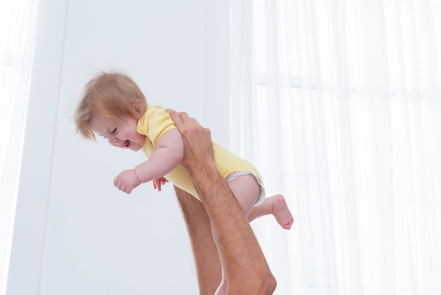 Foto gratuita bebé sonriente sostenido por el padre