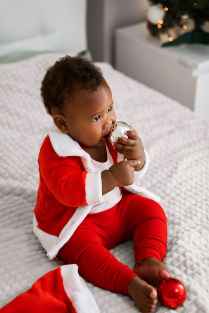 Foto gratuita bebé de tiro completo jugando con globo de navidad
