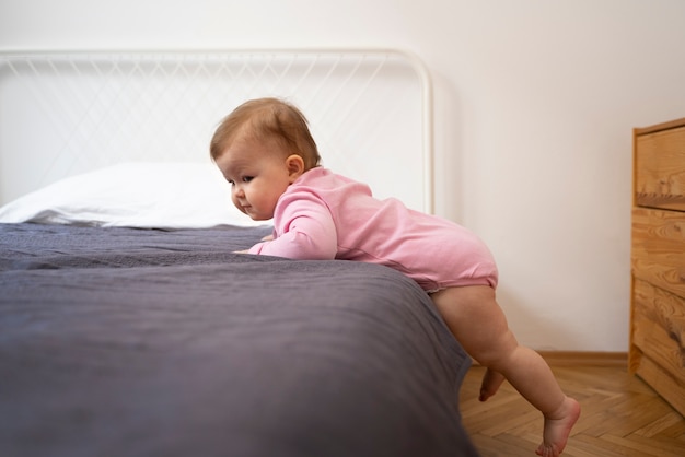 Foto gratuita bebé de tiro completo metiéndose en la cama