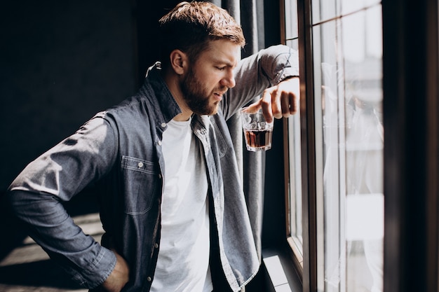 Bebedero hombre deprimido con botella de whisky