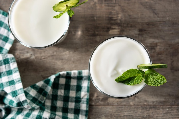 Bebida ayran con menta y pepino en vaso sobre mesa de madera