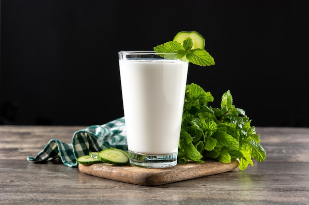 Bebida ayran con menta y pepino en vaso sobre mesa de madera