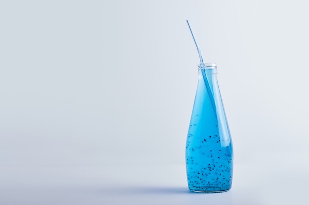 Bebida azul en una botella de vidrio.