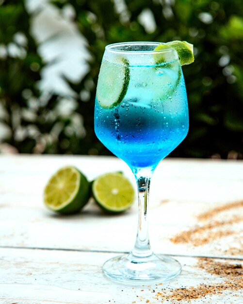 Bebida azul con rodajas de lima