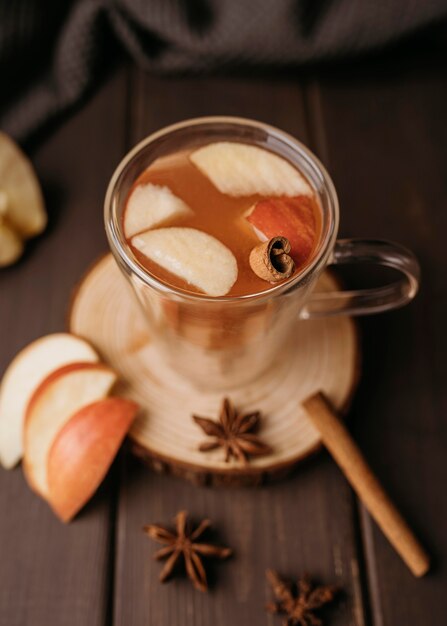 Bebida caliente de invierno de alto ángulo en vaso con manzana y canela