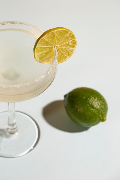 Bebida casera clásica margarita con limón y sal sobre fondo blanco.