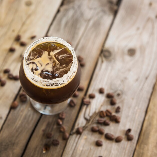 Bebida fría de café con hielo en el fondo de madera