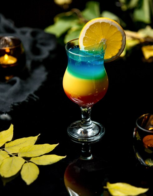 Bebida fría multicolor con una rodaja de naranja