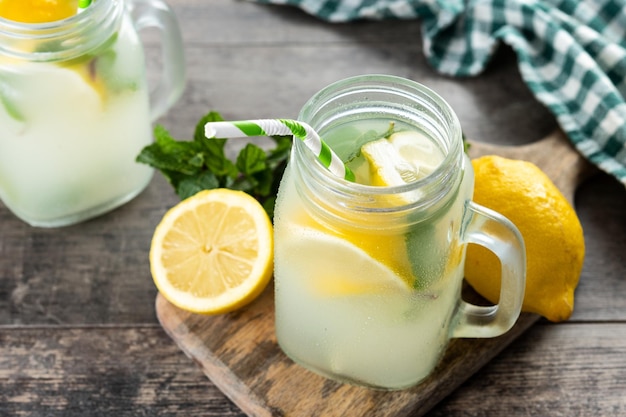 Bebida de limonada en un frasco de vidrio e ingredientes en una mesa de madera