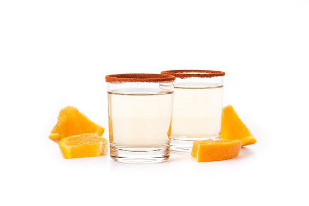 Bebida mexicana de mezcal con rodajas de naranja y sal de gusano aislada de fondo blanco