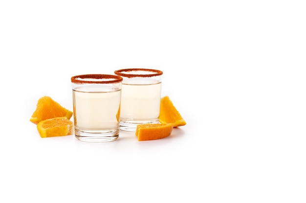 Bebida mexicana de mezcal con rodajas de naranja y sal de gusano aislada de fondo blanco