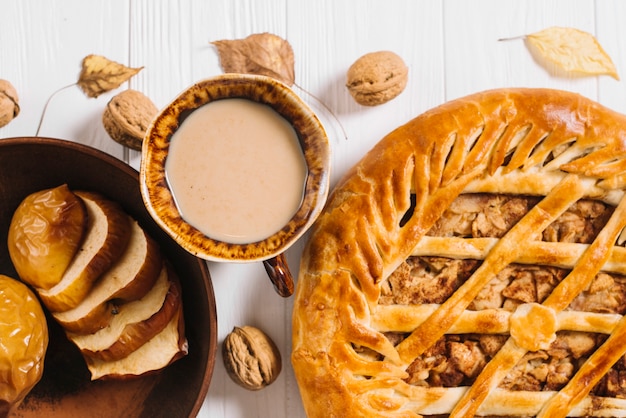 Foto gratuita bebida y nueces cerca de manzanas al horno y pastel